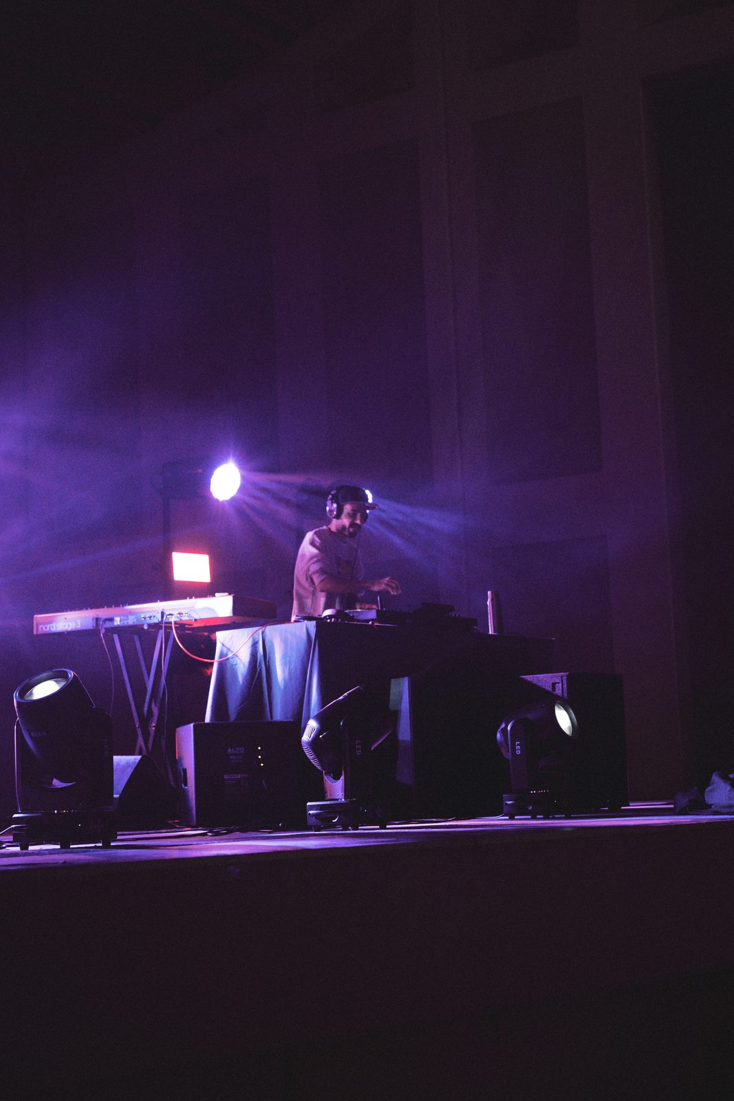 DJ performing on stage with purple stage lighting