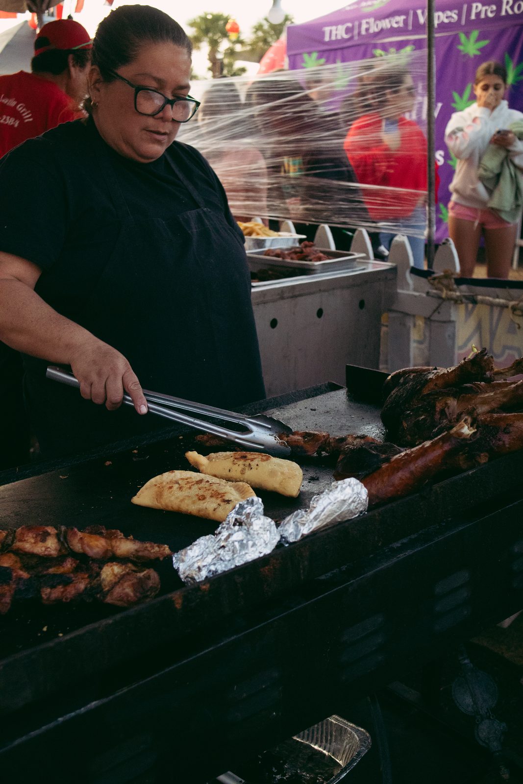 Vendor at a grill cooking food