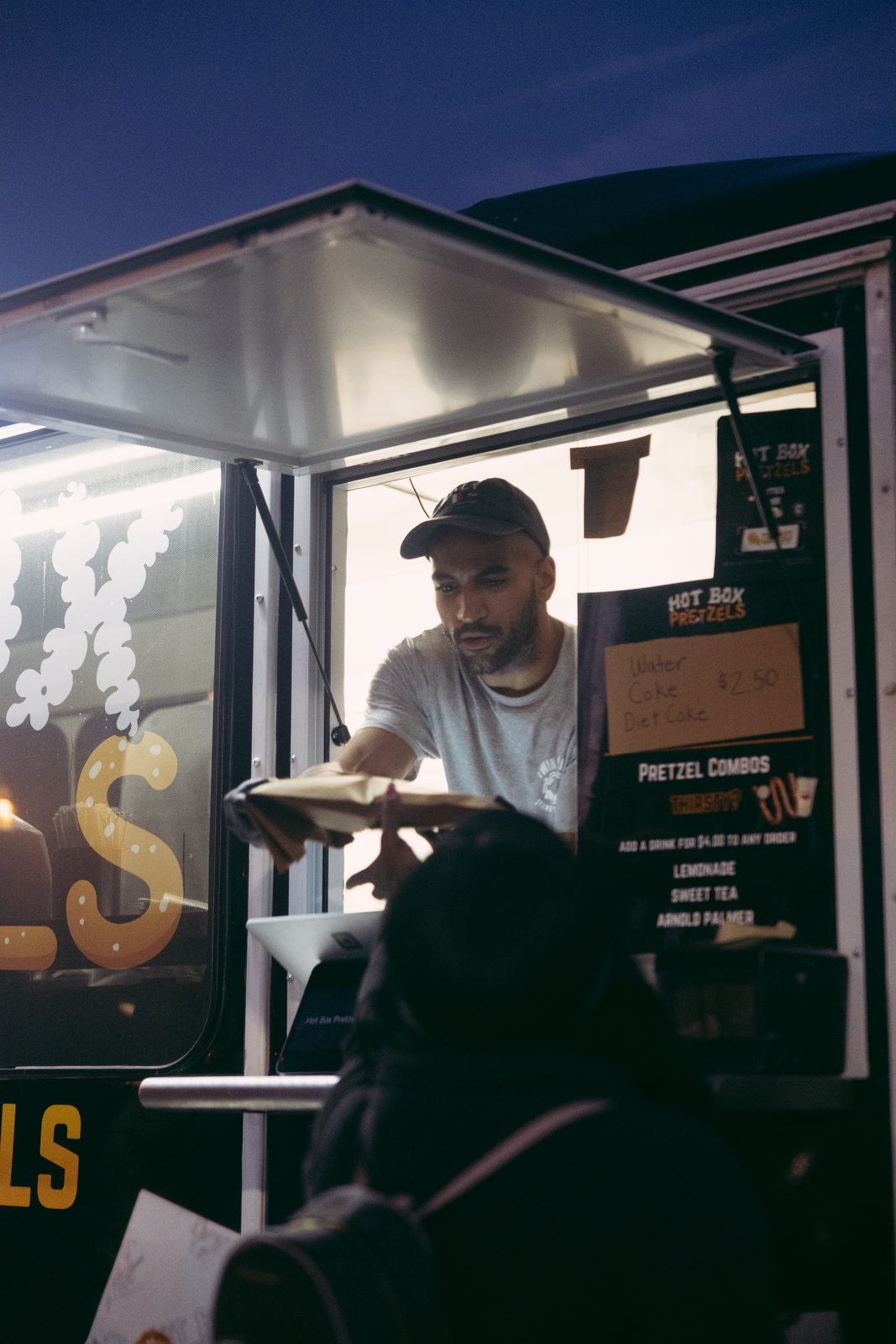 Hot Box Pretzels food truck vendor handing food to a customer